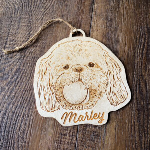 Wooden engraving of a shaggy dog named Marley with a tennis ball in his mouth