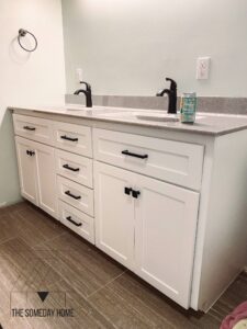 White vanity on gray tile flooring with gray top